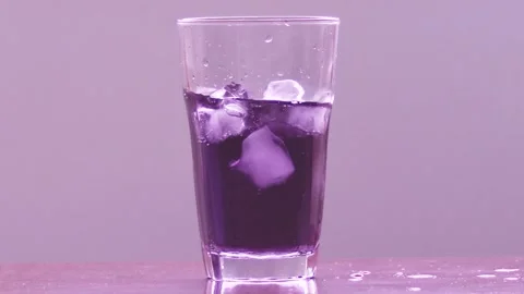Ices thrown into raspberry soda (slow motion) Stock Footage