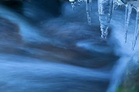 Icicle and river flow Stock Photos
