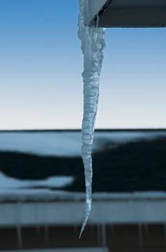Icicle hanging from rooftop single large Stock Photos