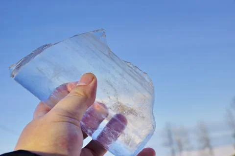 Icicle in his hands. shines on the sun. ice floe melts from the sun Stock-Fotos