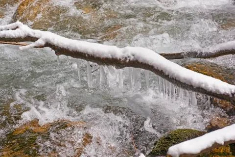 Icicles above a rushing stream Fotos Stock