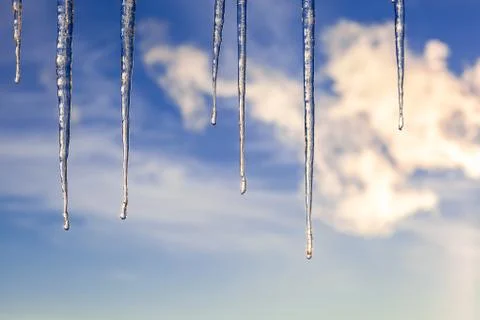 Icicles on the background of a blue sky. Stock Photos