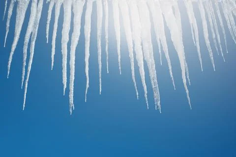 Icicles on a background of blue sky Stock Photos