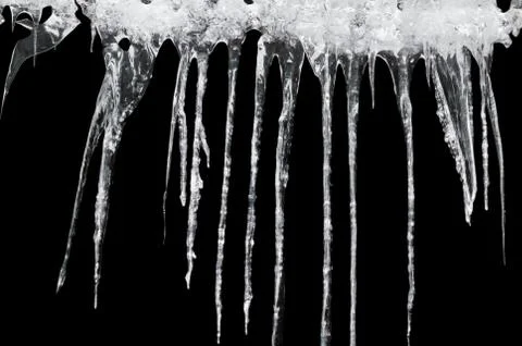 Icicles on a black background Stock Photos
