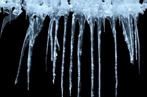 Icicles on a black background Stock Photos