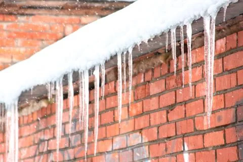 Icicles on a brick wall. snowfall Stock Photos