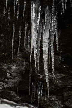 Icicles on dark background Stock Photos