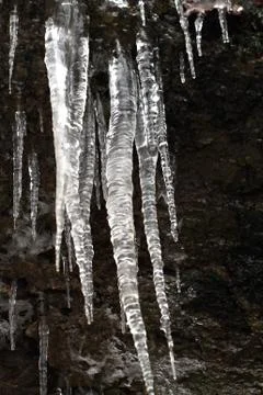 Icicles on dark background Stock Photos