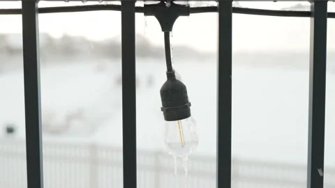 Icicles forming on an outdoor lightbulb during a snow storm - isolated Stock Footage 226877289