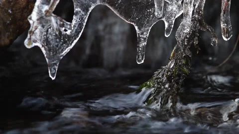Icicles hang over a fast stream Stock Footage 146252185