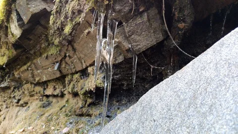Icicles hang from stones in the spring and melt away Stock Footage 129394522