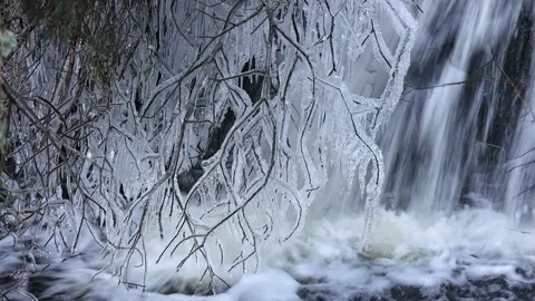 Icicles Hanging from Branches Next to a Waterfall, UK Video stock 227886129