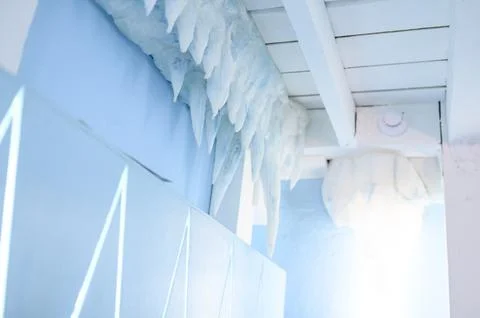 Icicles hanging from ceiling in bright blue interior space Stock Photos