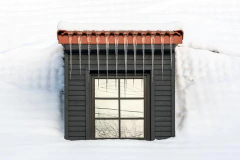 Icicles hanging from the dormer Stock Photos