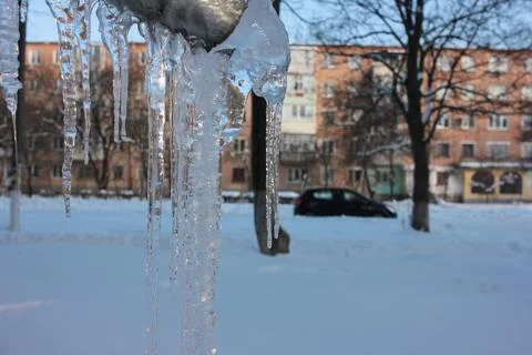Icicles hanging on a gutter on the house background. Foto stock