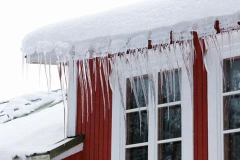 Icicles hanging over windows Stock Photos