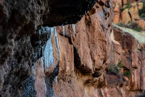 Icicles hanging on rock Stock Photos