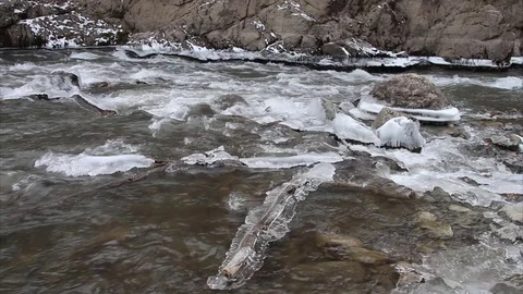 Icicles on a log in quickly current stream of the river Stock Footage 73561810