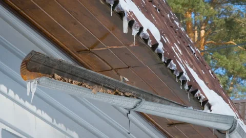 Icicles Melt and Dripping on the Sun while Hanging from the Roof of a Wooden Stock Footage 152364771