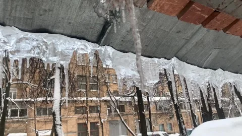 Icicles melt and drops of water drip from roof Stock Footage 263328246