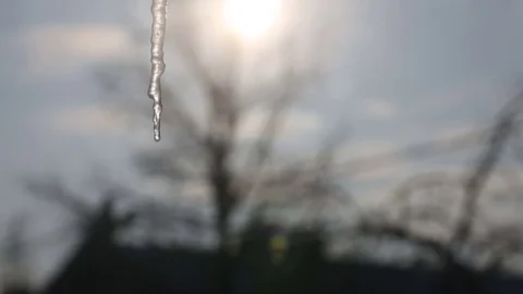 Icicles melt through the window as the sun rises in the background Video stock 72198435