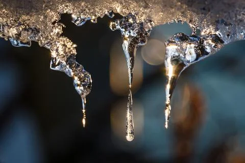 Icicles or ice stalactites backlit with the sun Stock Photos
