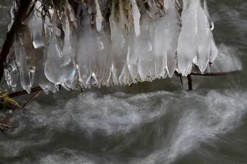 Icicles over stream Stock Photos