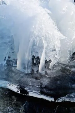 Icicles on the small mountain creek Stock Photos