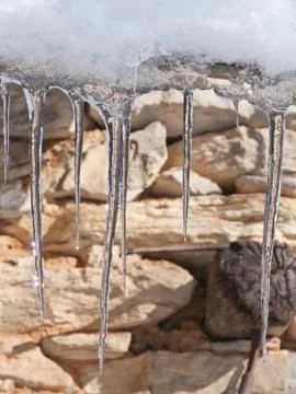 Icicles on stone wall Stock Photos