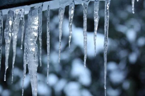 Icicles which are hanging down from a roof. Stock Photos