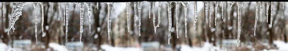 Icicles which are hanging down from a roof Stock Photos