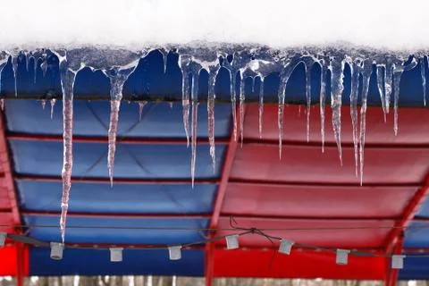 Icicles which are hanging down from a roof Stock Photos