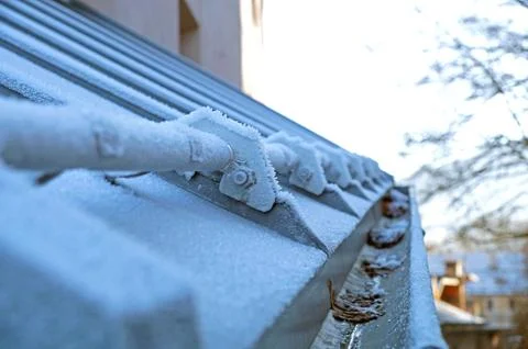 Icicles which are hanging down from a roof Stock Photos
