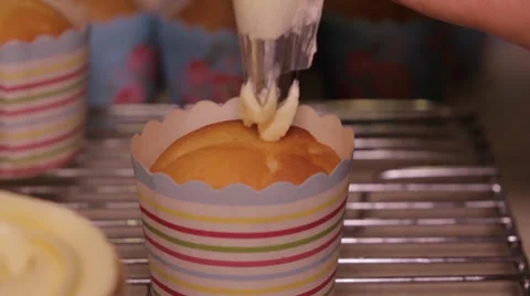 Icing mixture being laid on cupcake 库存影片 39842528