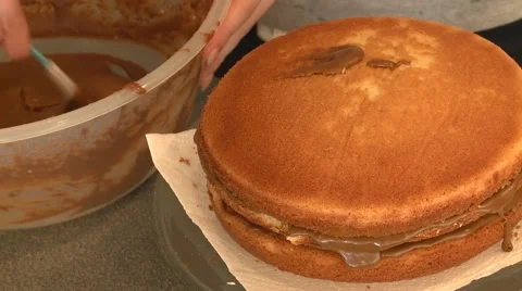 Icing a sponge cake after home baking Stock Footage 55197694