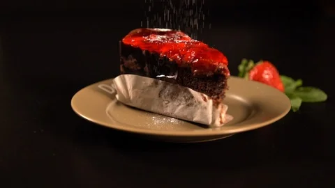 Icing sugar being drizzled onto a slice of cake Stock Footage 94077838