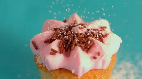 Icing sugar being sieved on pink frosted cupcake Vidéo 33388152