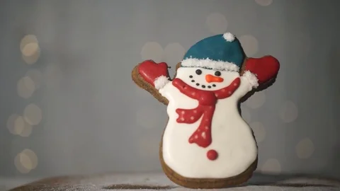 Icing sugar falls on a gingerbread, snowman figure with colored glaze Stock Footage 70790945