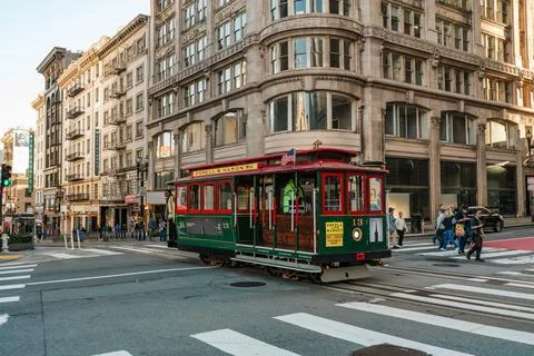 Iconic cable car rides through the bustling streets lined with San Francisc.. Stock Photos