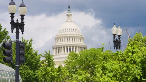  Iconic Capitol dome rises above lush greenery under dramatic stormy skies in Wa Stock Footage 310860347