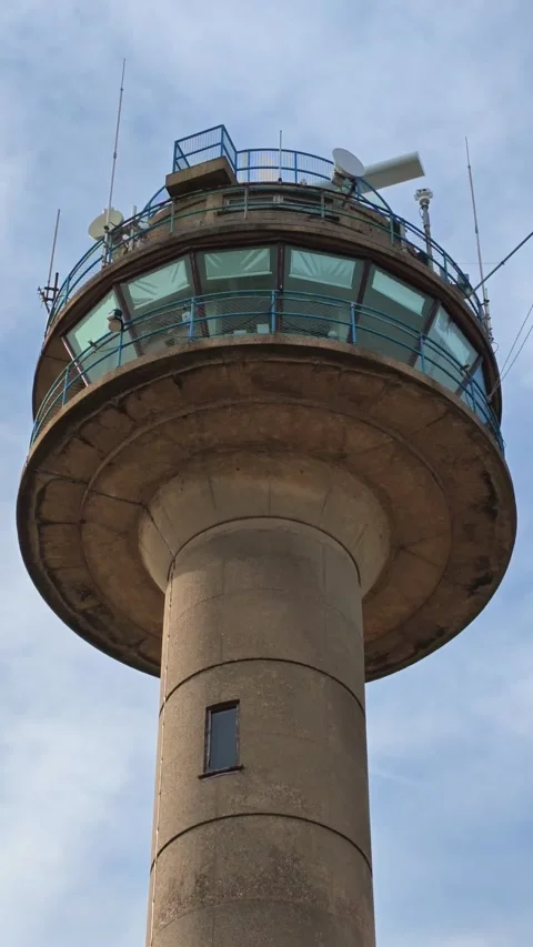 Iconic coastguard tower with radar and flags against a cloudy sky Stock Footage 342405378