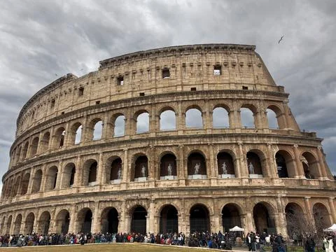 Iconic Colosseum with dramatic cloudy sky and Stock Photos