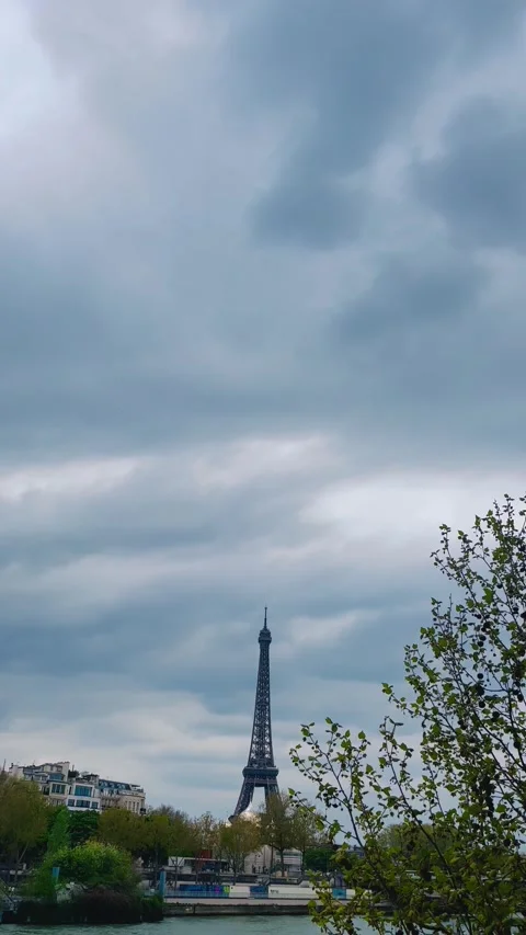 Iconic Eiffel tower over Seine river in Paris France with green tree in spring Vídeo Stock 347649932