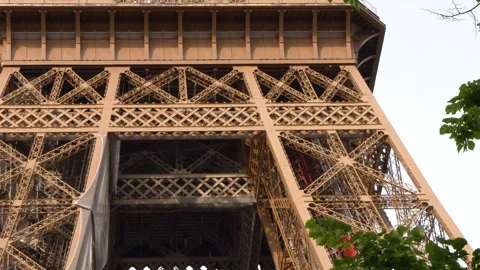 Iconic Eiffel Tower Structure Framed by Green Tree Foliage in Paris Stock Footage 334360884