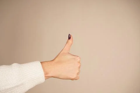 The iconic "like" gesture conveys support and agreement. Set against a clean Foto stock