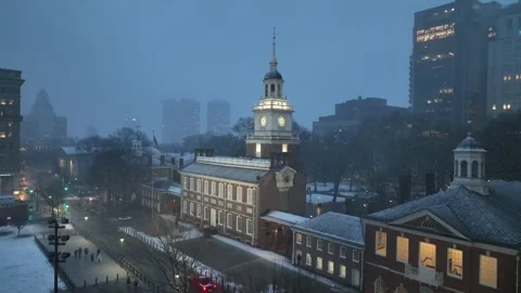 Iconic Independence Hall in Philadelphia during winter snowfall at dusk Stock Footage 328993687
