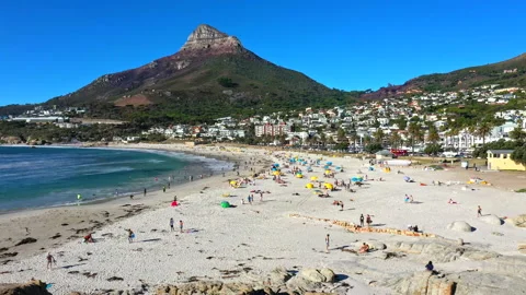 The iconic Lion's head mountain towering behind the gorgeous Camps Bay beach Stock Footage 170726024