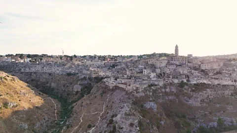 Iconic Matera city and deep valley during golden hour, aerial view Video stock 319757151