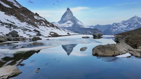 Iconic Matterhorn view with reflection in lake Riffelsee at sunrise, symbol of Stock Footage 195951292