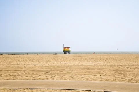 The iconic rainbow-colored pride lifeguard tower on the wide sandy shore of.. Stock Photos